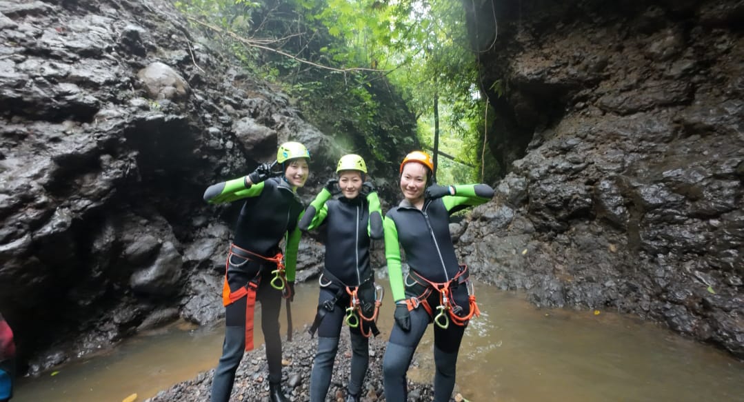 Peserta Canyoning Bali berpose di ngarai dengan perlengkapan Canyoning lengkap.